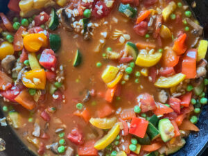 Vegetarian Paella Recipe, ingredients in a pan, vegetable broth, vegetables, arborio rice