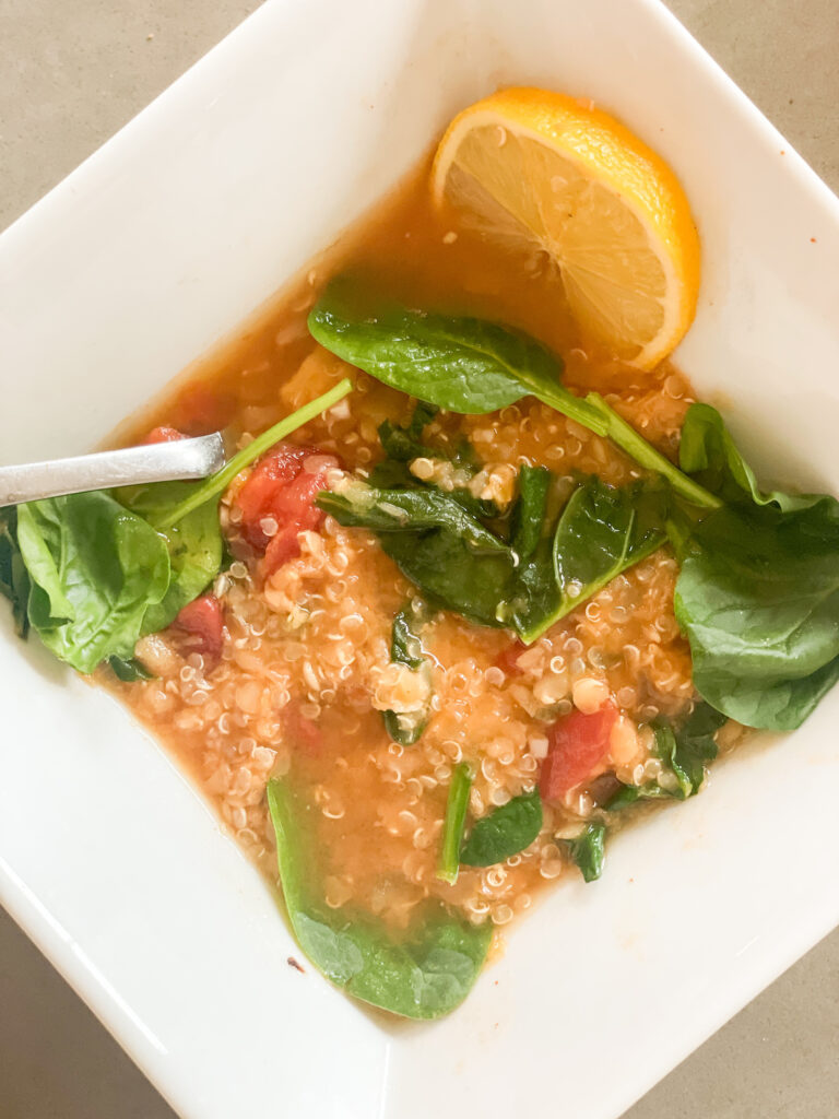 panera lentil quinoa bowl recipe with a lemon wedge and fresh spinach leaves